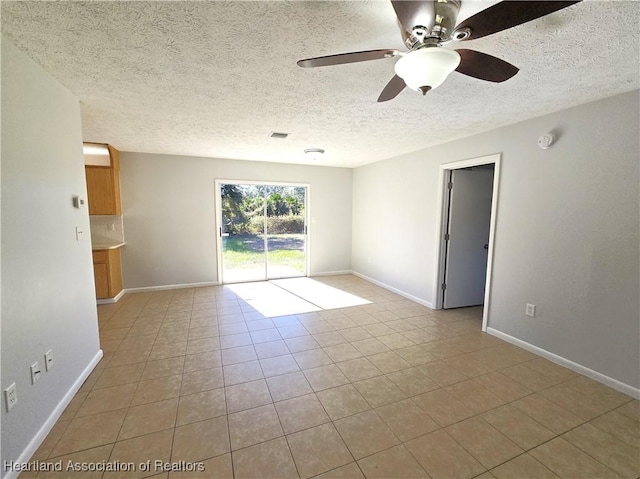 tiled empty room featuring a textured ceiling and ceiling fan