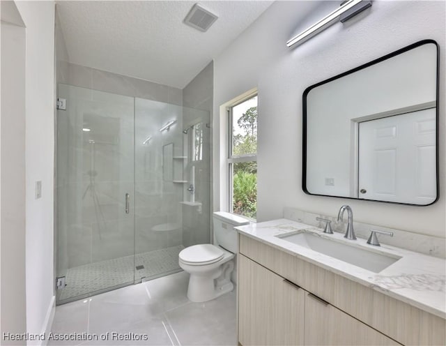 bathroom with tile patterned floors, a textured ceiling, toilet, vanity, and a shower with shower door