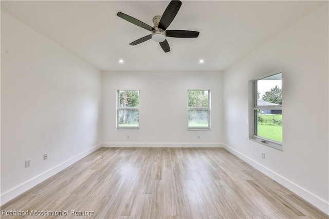 empty room with ceiling fan and light hardwood / wood-style flooring