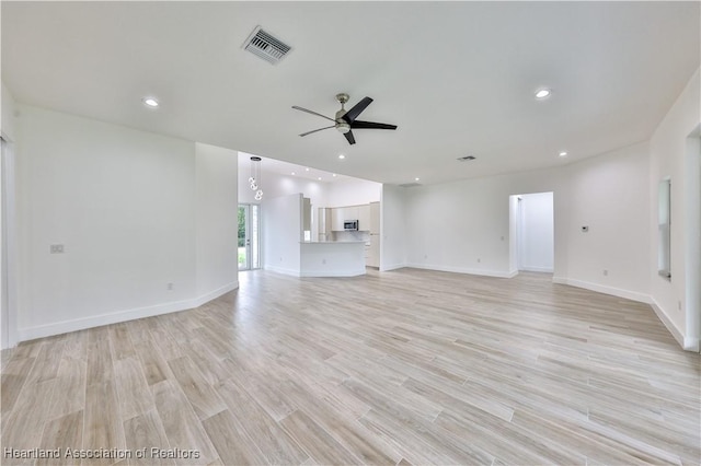 unfurnished living room featuring ceiling fan and light wood-type flooring