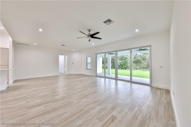 empty room with ceiling fan and light hardwood / wood-style floors