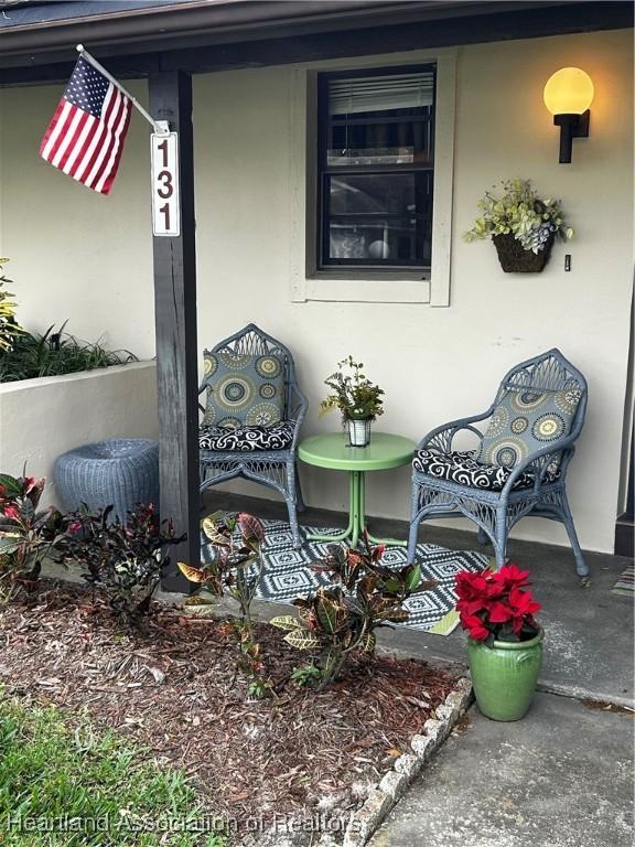 doorway to property with a porch and stucco siding