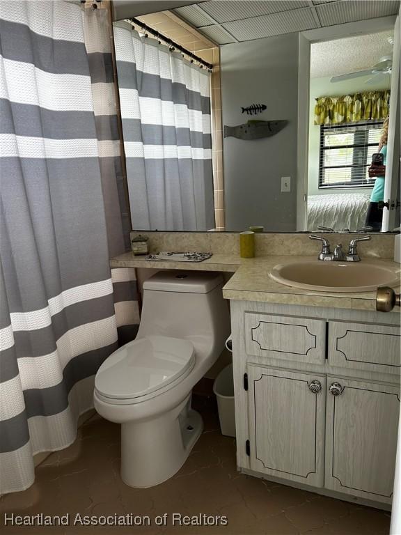 bathroom with ensuite bathroom, vanity, toilet, and a ceiling fan