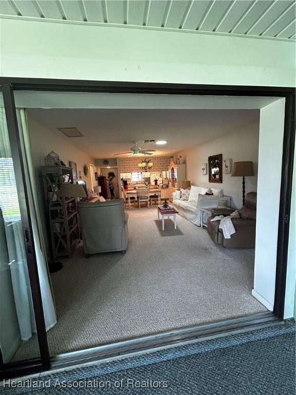 unfurnished living room featuring carpet and ceiling fan