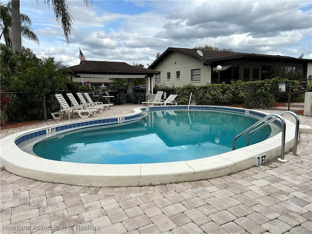 pool with a patio area and a gazebo