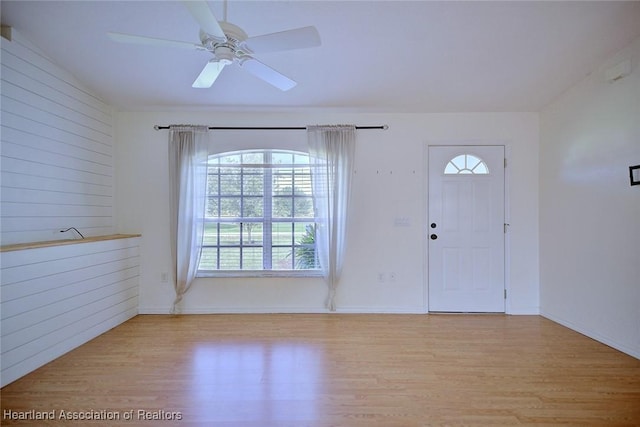 33064 Grand Prix Dr, Sebring, FL 33872 - foyer featuring light wood-style flooring, a ceiling fan, baseboards, and wooden walls