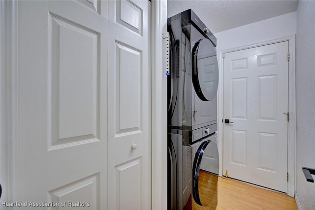 33064 Grand Prix Dr, Sebring, FL 33872 - washroom with stacked washing machine and dryer and light wood-style flooring