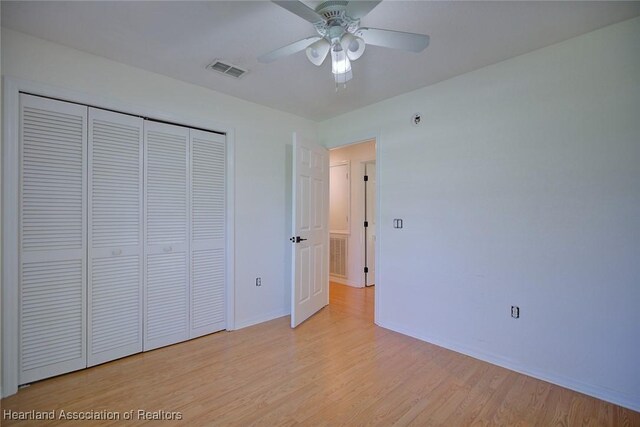 33064 Grand Prix Dr, Sebring, FL 33872 - unfurnished bedroom with light wood-style flooring, baseboards, a closet, and a ceiling fan