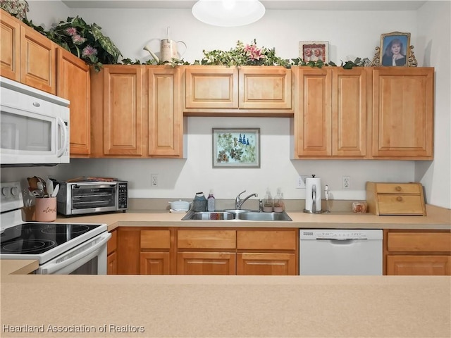 kitchen featuring white appliances, light countertops, a sink, and a toaster