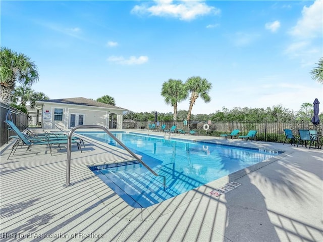 pool featuring a patio, french doors, and fence