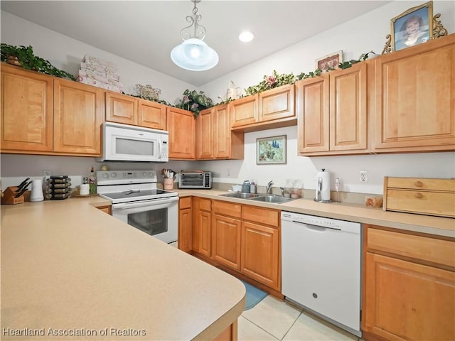 kitchen featuring light tile patterned flooring, white appliances, a sink, light countertops, and decorative light fixtures