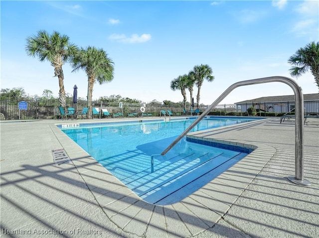 community pool featuring fence and a patio