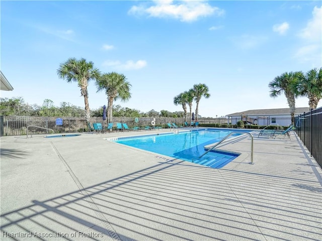 pool with a patio and fence