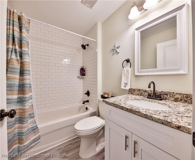 full bathroom featuring hardwood / wood-style flooring, shower / tub combo, vanity, and toilet