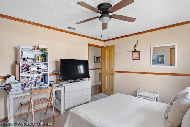 bedroom featuring light colored carpet, visible vents, ornamental molding, a ceiling fan, and a textured ceiling