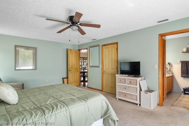 bedroom featuring light carpet, ceiling fan, a textured ceiling, and visible vents