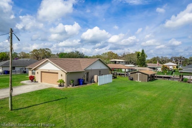 ranch-style home featuring a garage, driveway, a front yard, and fence