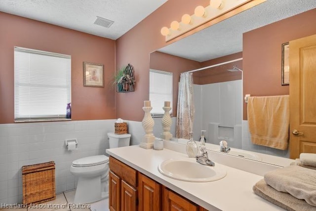 bathroom with curtained shower, visible vents, toilet, a textured ceiling, and vanity