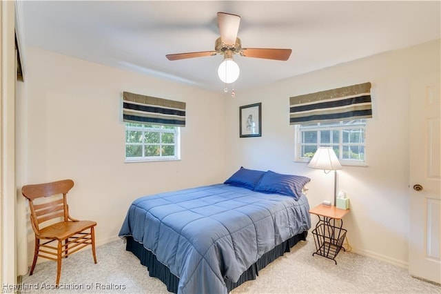 carpeted bedroom featuring ceiling fan and multiple windows