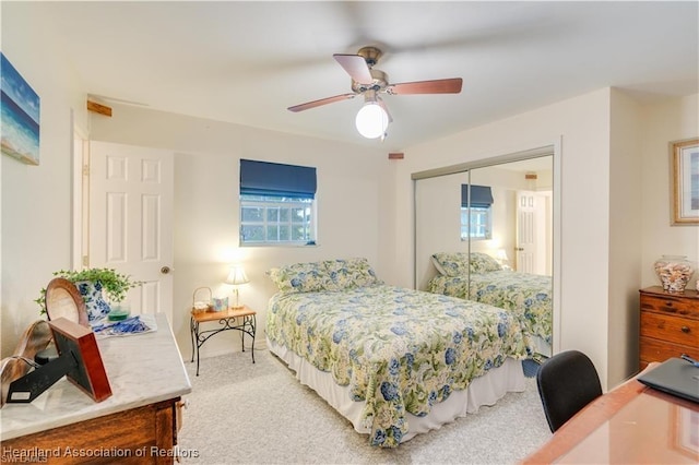 bedroom featuring ceiling fan, light colored carpet, and a closet