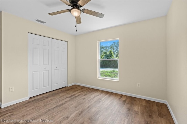 1100 Redbird St, Lake Placid, FL 33852 - unfurnished bedroom with baseboards, wood finished floors, a closet, and ceiling fan