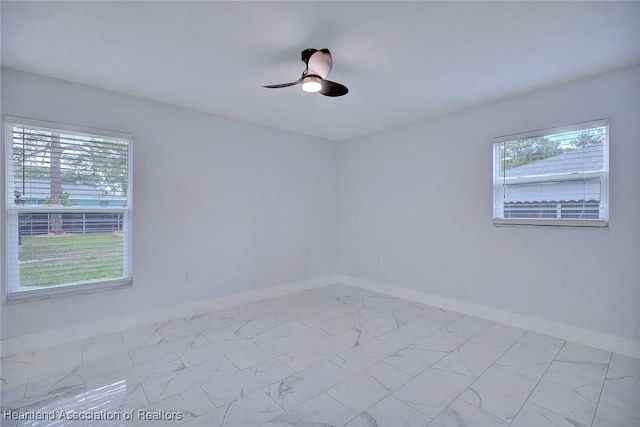 spare room featuring ceiling fan and a healthy amount of sunlight