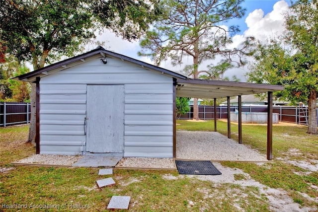 view of outdoor structure with a yard and a carport