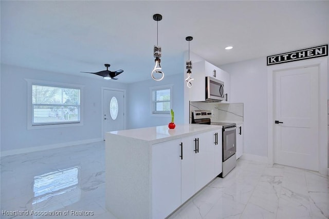 kitchen with white cabinetry, ceiling fan, stainless steel appliances, and decorative light fixtures