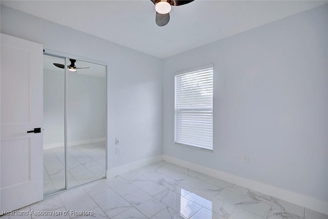 unfurnished bedroom featuring ceiling fan and a closet