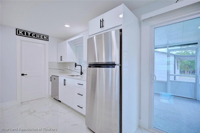 kitchen featuring sink, white cabinetry, stainless steel appliances, and tasteful backsplash