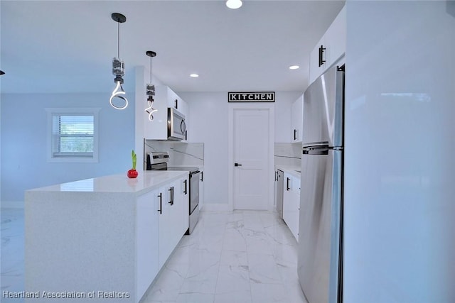 kitchen featuring white cabinetry, stainless steel appliances, and hanging light fixtures