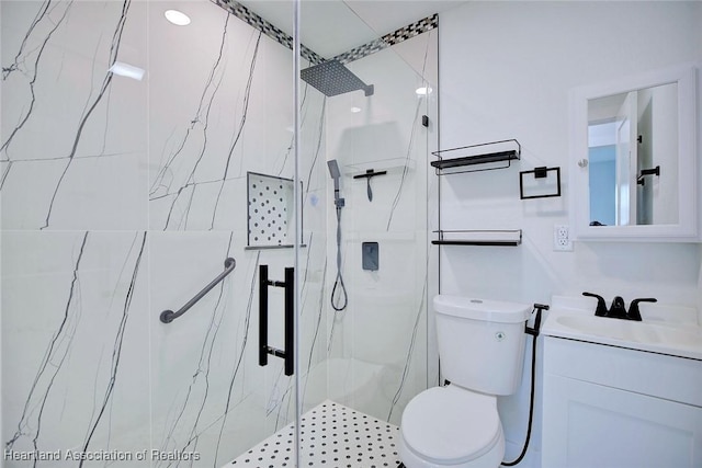 bathroom featuring vanity, toilet, and a shower with shower door