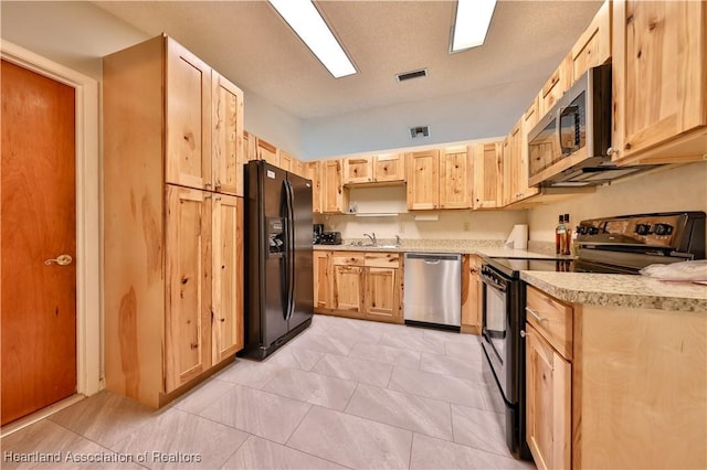 232 Dove Ave, Sebring, FL 33870 - kitchen featuring black appliances, light brown cabinetry, and a sink