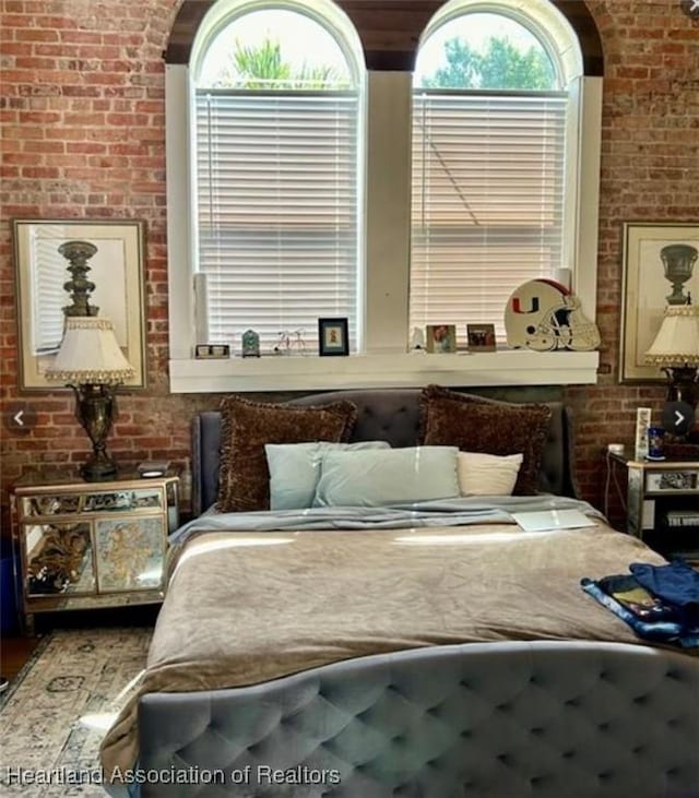 bedroom featuring brick wall