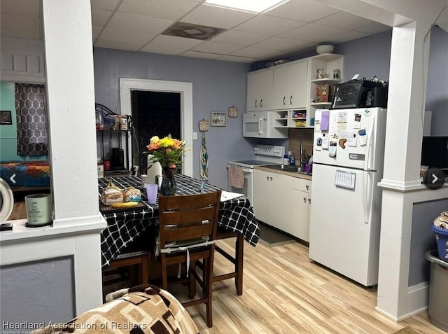 kitchen featuring white cabinets, white appliances, a paneled ceiling, and light wood-type flooring