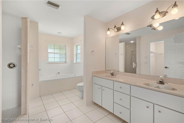 bathroom featuring tile patterned floors, a bathing tub, vanity, and toilet