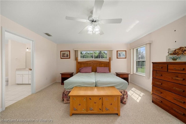 carpeted bedroom with ensuite bath and ceiling fan