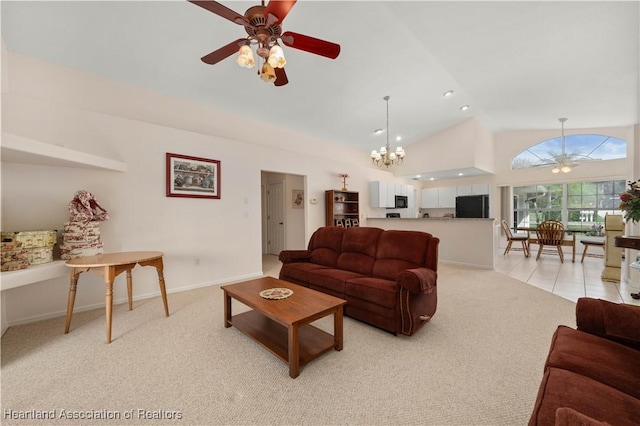 carpeted living room featuring ceiling fan with notable chandelier and high vaulted ceiling