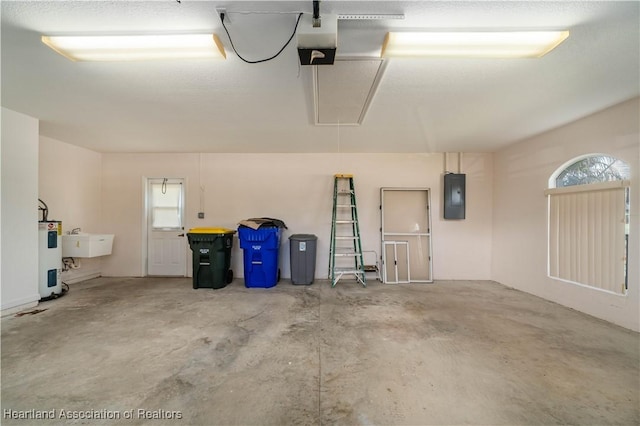 garage featuring electric water heater, electric panel, a garage door opener, and sink