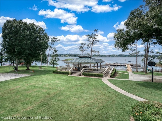 dock area featuring a gazebo, a water view, and a lawn