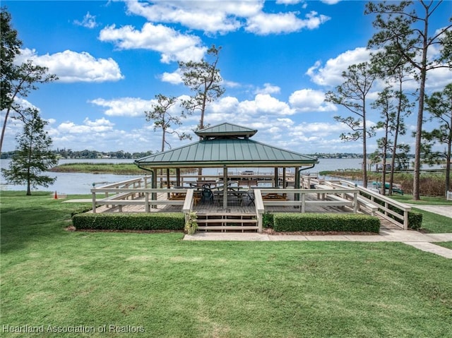 view of dock with a gazebo, a yard, and a water view