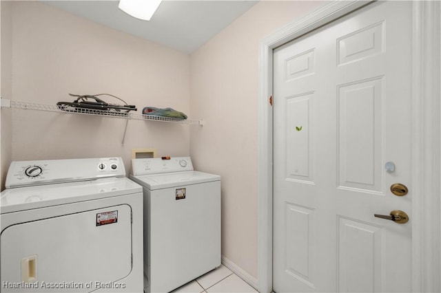 laundry area with light tile patterned floors and washing machine and dryer