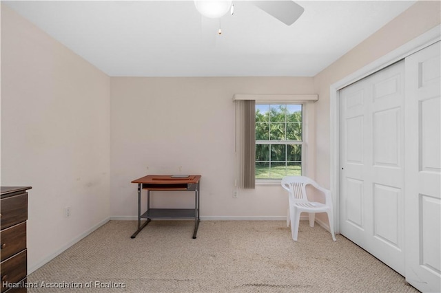 interior space featuring ceiling fan and light colored carpet