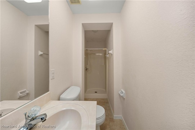 bathroom featuring a shower, tile patterned flooring, toilet, and sink