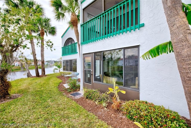 exterior space with a water view and a lawn