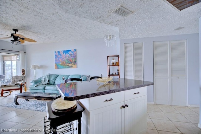 kitchen with white cabinetry, light tile patterned floors, and a kitchen island