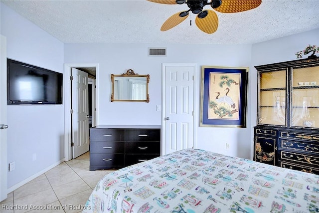 bedroom with ceiling fan, a textured ceiling, and light tile patterned floors