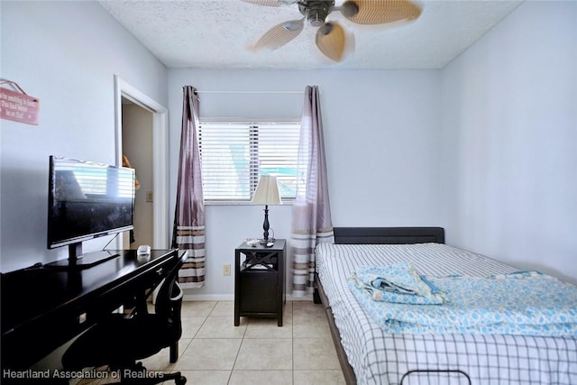 bedroom with ceiling fan, light tile patterned floors, and a textured ceiling