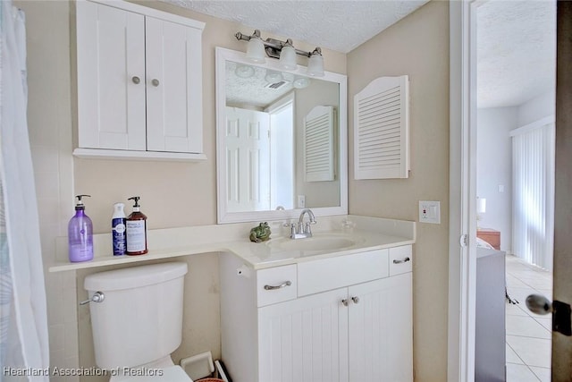 bathroom featuring a healthy amount of sunlight, vanity, toilet, and a textured ceiling