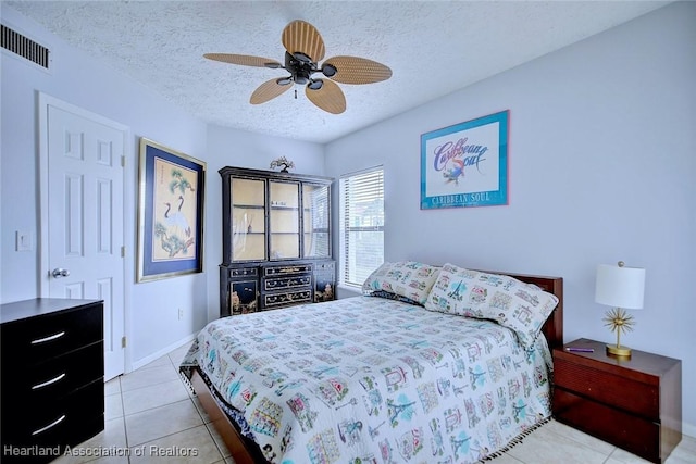 bedroom with ceiling fan, a textured ceiling, and light tile patterned floors